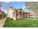 A view of the side of this home showing off mature landscaping and a comfortable covered front porch at 239 Euclid Ave, Statesville, NC 28677