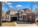Attractive two-story home with a brick and vinyl exterior, well-manicured lawn, and an attached garage at 304 Keller St, China Grove, NC 28023