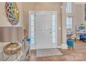 Welcoming foyer features a white front door with sidelights, a stylish rug, and gleaming hardwood floors at 304 Keller St, China Grove, NC 28023