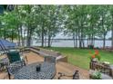 Lush backyard with mature trees, a wooden deck, and beautiful lake views at 405 Northwest Dr, Davidson, NC 28036