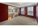 Bright living room with dark red walls, with an archway leading to the dining room at 509 Riviera Pl, Rock Hill, SC 29730