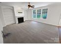 Living room with fireplace, built-in bookshelves, and large windows offering plenty of natural light at 6409 Chadwell Ct, Fort Mill, SC 29707