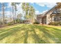 Expansive backyard showcasing mature trees and a covered patio area for entertaining at 7674 Bermuda Hills Ln, Denver, NC 28037