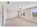 Bright, carpeted bedroom with ceiling fan and large windows offering ample natural light at 8007 Shadbrush Ct, Charlotte, NC 28215