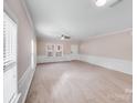 Bright and spacious living room featuring neutral carpet, wainscoting, and large windows at 8007 Shadbrush Ct, Charlotte, NC 28215