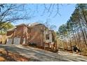 Rear exterior view of the home featuring a 2-car garage and outdoor fireplace in a wooded setting at 9135 Fair Oak Dr, Sherrills Ford, NC 28673