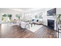Bright living room with a fireplace, hardwood floors, and large windows at 103 Noah Ln, Troutman, NC 28166