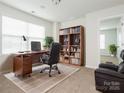 Well-lit home office offers built-in bookshelves, a comfortable workspace, and a serene atmosphere at 10335 Rutledge Ridge Nw Dr, Huntersville, NC 28078