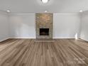 Bright living room featuring a stone fireplace, new flooring, and ample space at 10906 Falls Branch Ln, Charlotte, NC 28214