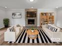 Stylishly staged living room with a stone fireplace, modern furniture, and striped rug at 10906 Falls Branch Ln, Charlotte, NC 28214