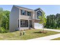 Two-story home shows light brown siding, a two-car garage, and a neatly kept lawn and sidewalk at 111 Rustling Waters Dr, Mooresville, NC 28117