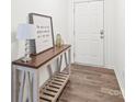 Neutral entryway with a wooden console table, decorative lamp, and framed artwork, with wood flooring at 112 Buoy Ln, Statesville, NC 28677