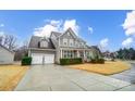 View of a two-story home with attached garage, long driveway, and well-maintained lawn at 1126 Snowbird Ln, Waxhaw, NC 28173