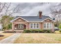 Charming brick home featuring a well-manicured lawn and cozy front porch with a porch swing at 119 Hemphill Ave, Chester, SC 29706