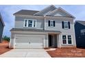 Charming two-story home with light blue siding, a white garage door and black window shutters at 13248 Chopin Ridge Rd, Huntersville, NC 28078