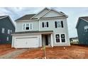 Charming two-story home with a light-colored exterior, a two car garage, and an unfinished front yard at 13248 Chopin Ridge Rd, Huntersville, NC 28078