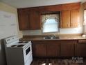 The kitchen features wood cabinets, a stainless steel sink, and white appliances at 146 Loomis St, Chester, SC 29706