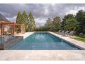 Backyard pool area with lounge chairs and pergola for relaxing and enjoying the outdoors at 1506 Venetian Way Dr, Waxhaw, NC 28173