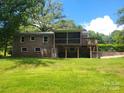 Spacious backyard with brick home, screened porch, and wooden deck, perfect for outdoor gatherings at 1552 10Th Street Nw Pl, Hickory, NC 28601