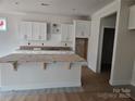 Bright kitchen with white cabinets, subway tile backsplash, large island and stainless steel appliances at 231 Miramar Dr, York, SC 29745