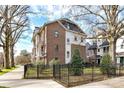 Townhome exterior with brick and siding, complemented by black fencing and manicured landscaping at 3064 Selwyn Ave, Charlotte, NC 28209