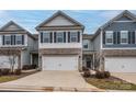 Inviting townhome showcases a two-car garage, stone accents, and a welcoming entrance at 4242 Plumeria Way, Fort Mill, SC 29707