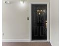 Black front door with gold hardware, peephole, and the number 6464 above the door at 6464 Park Pond Dr # 7, Charlotte, NC 28262