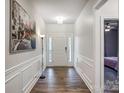 Bright entryway with hardwood floors, white wainscotting and a modern black and white art print at 6858 Hunts Mesa Dr, Fort Mill, SC 29707
