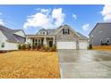 Charming home with a stone facade, three-car garage, and manicured landscaping at 6858 Hunts Mesa Dr, Fort Mill, SC 29707