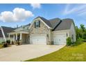 Charming home with stone accents, inviting curb appeal, and a two car garage at 6858 Hunts Mesa Dr, Fort Mill, SC 29707