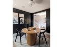 Contemporary dining area featuring black walls, modern artwork, and a unique table at 7003 Impulse Ct, Charlotte, NC 28205