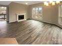 An airy living room with hardwood floors, a fireplace, and a large window, creating a comfortable and inviting atmosphere at 8069 Cedar Glen Dr, Charlotte, NC 28212
