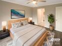 Staged bedroom with a wooden bed frame, hardwood floors, and a plant for a calm and inviting atmosphere at 8069 Cedar Glen Dr, Charlotte, NC 28212