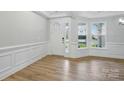 Bright entryway featuring wood-look floors, white wainscoting, a paneled door, and double-paned windows at 8716 Acadia Pkwy # 596, Sherrills Ford, NC 28673