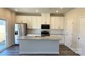 Modern kitchen with white cabinets, stainless steel appliances, and a granite-top island at 1105 Harry Ct, Albemarle, NC 28001