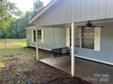 Cozy back porch features a swing and ceiling fan at 13080 Philadelphia Church Rd, Oakboro, NC 28129