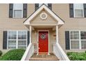 Charming townhouse entrance featuring a vibrant red door, white railings and a welcoming wreath at 1469 Flintwood Dr, Rock Hill, SC 29732
