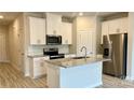 Modern kitchen features white cabinets, granite countertops, stainless steel appliances, and a central island at 1760 Braemar Village Dr, Monroe, NC 28110