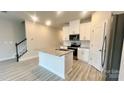 Bright kitchen features a center island, granite countertops, stainless steel appliances, and ample cabinet space at 1760 Braemar Village Dr, Monroe, NC 28110