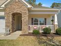 Close up of the home's stone entryway and inviting front porch with seating at 1874 Larkspur Way, Tega Cay, SC 29708