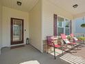 Inviting front porch featuring a seating area with rocking chairs and decorative accents at 1874 Larkspur Way, Tega Cay, SC 29708