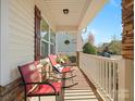 Side view of the front porch featuring rocking chairs and decorative accents at 1874 Larkspur Way, Tega Cay, SC 29708