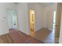 Bright entryway with tile flooring, leading to a powder room and other rooms with newly installed flooring at 212 Mary Caroline Springs Dr, Mount Holly, NC 28120
