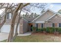 Charming brick home with a well-manicured lawn and dark shutters, complemented by mature trees and a two car garage at 212 Mary Caroline Springs Dr, Mount Holly, NC 28120