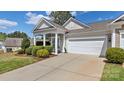 Inviting home exterior with a manicured lawn, a covered porch, and attached two-car garage at 3008 Sweetleaf Dr, Fort Mill, SC 29707