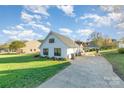 White home with black trim featuring lush green lawn, driveway, and carport, set against a bright blue sky at 317 Commodore Loop, Mooresville, NC 28117