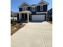 Two-story home features a concrete driveway leading to a spacious two-car garage, offering ample parking at 334 Knotty Wood Dr # 68, Monroe, NC 28110