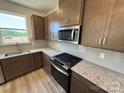Galley kitchen featuring stainless steel appliances, granite countertops, and modern cabinets at 334 Knotty Wood Dr # 68, Monroe, NC 28110