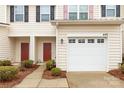 Close up of townhome entrance with a red door, garage, and manicured shrubbery in the front at 446 Clouds Way Way, Rock Hill, SC 29732