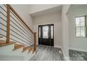 Bright foyer showcases wood stairs with metal railing and a modern front door with decorative glass at 5125 Isaac Dr, Charlotte, NC 28216